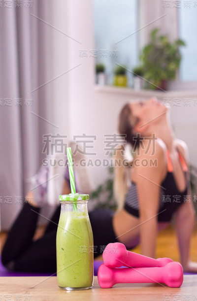 奶昔和哑铃在锻炼的女孩面前