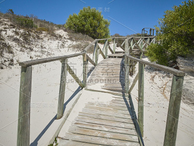 在Langebaan泻湖西岸国家公园的海滩，海岸上有岩石，海滩前有蓝色的水