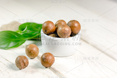 白色木桌上放着漂亮的澳洲坚果。