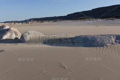 石头从沙子中伸出来。彩砂。背景来自细沙。