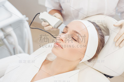 美容师在一个女孩客户脸上做微电流治疗