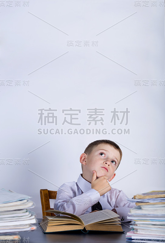 靠在一堆书上思考的小孩