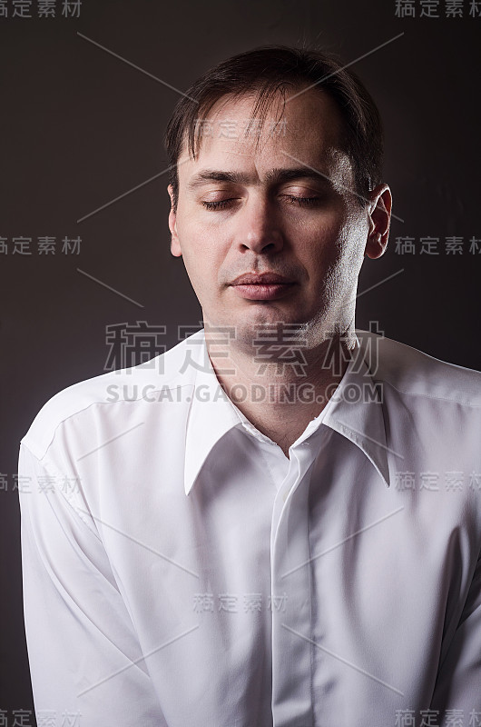 穿着白衬衫的疲惫男子闭上了眼睛