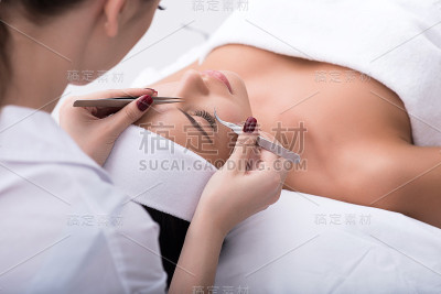 接受睫毛延长手术的专业美容师