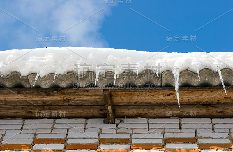 雪覆盖的屋顶上有冰柱