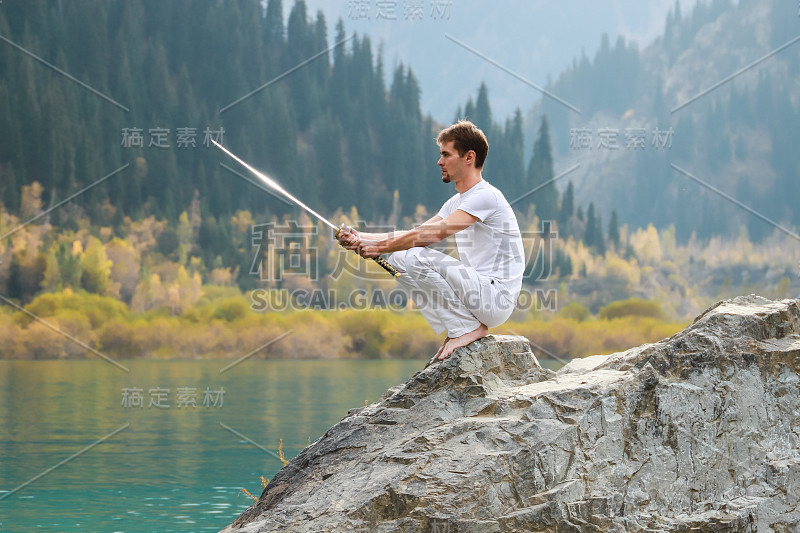 一个聪明人坐在石头上，手里拿着一把剑。山湖背景