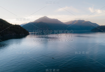 航拍独木舟在平静的水面上，日落