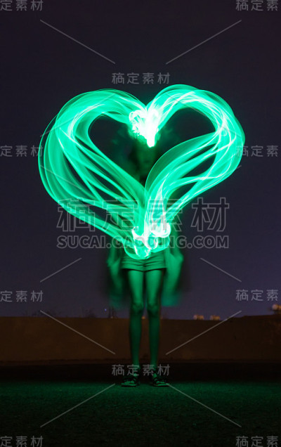 小女孩有绿色的心。光绘速度。冻结的光。