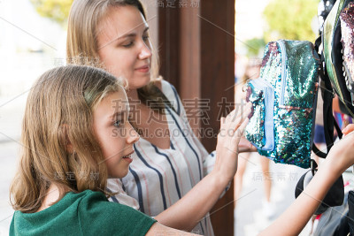 妈妈和她的女儿在商店选择背包。