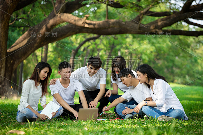 一群人在公园开会，用笔记本电脑进行团队合作