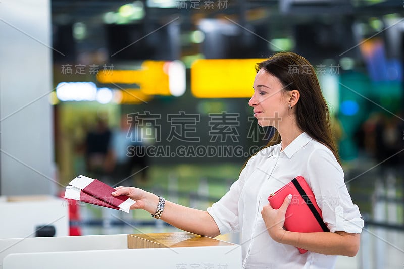 在机场拿着护照和登机牌的年轻女孩