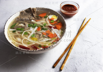 越南粉煲汤，亚洲美食，美味的汤在灰色的背景和辣酱