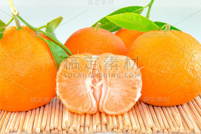 用木棒切成片和叶子的橘子