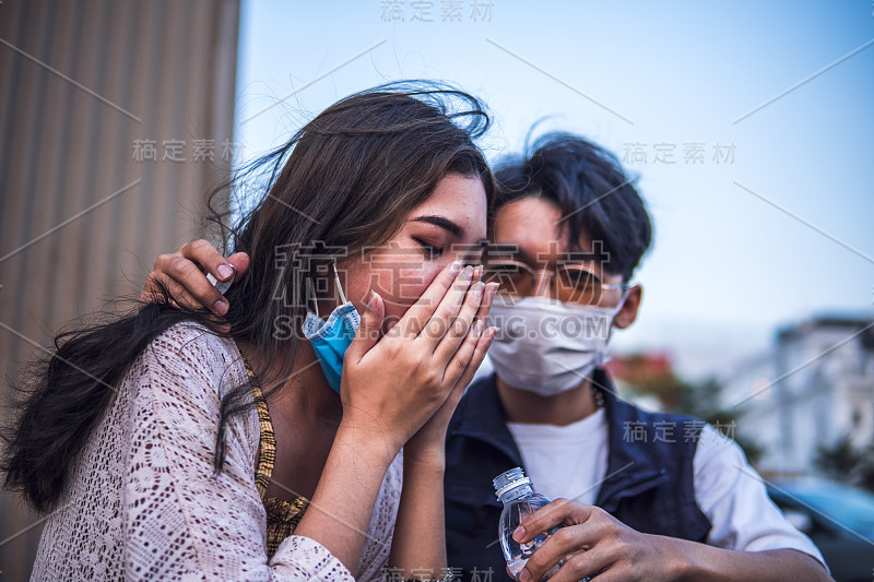 不健康的亚洲妇女打喷嚏和咳嗽防护口罩，而男子试图帮助