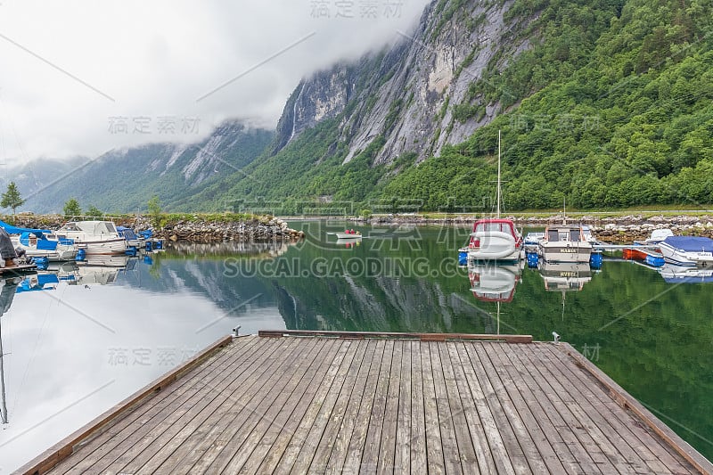 Molde，挪威- 2016年6月7日:码头，渔船与水的倒影，山在挪威的背景