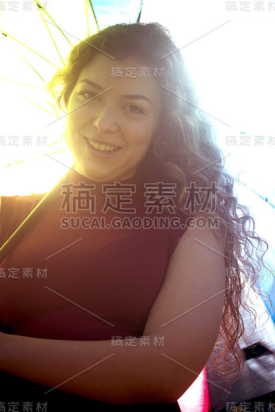一个在阳光明媚的日子里打着伞的漂亮女人