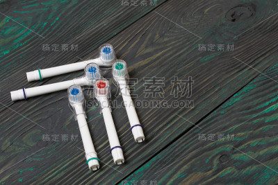 牙刷的喷嘴。有不同颜色的鬃毛。躺在刷过的松木板上。