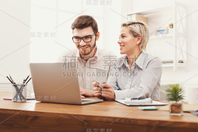 一对年轻的同事在现代办公室工作