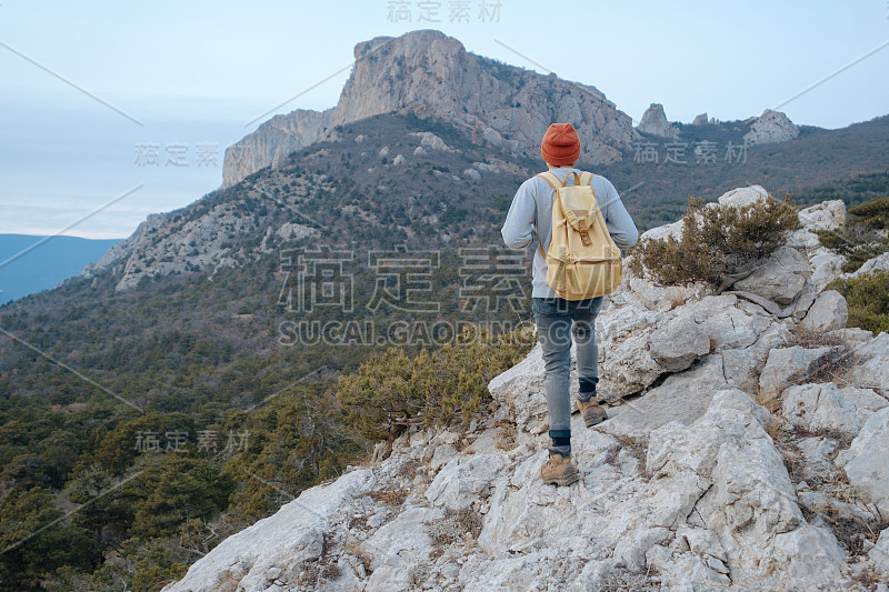 男人背包徒步旅行和红帽子在山区