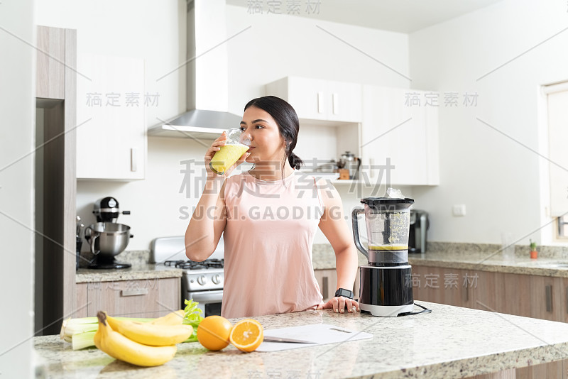 华丽的女人在家里喝饮料