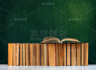 回到学校，堆着书本，带着空白的绿校板背景，教育理念