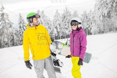 在雪山上玩滑雪板