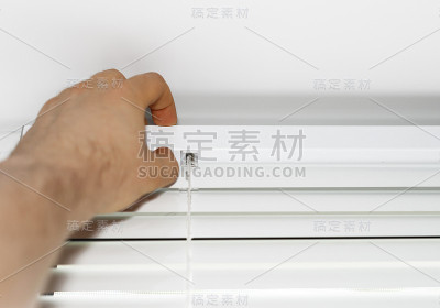 男子在窗户上安装活动百叶窗。