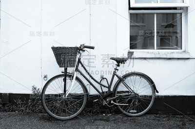 旧自行车在一间小屋的窗户旁