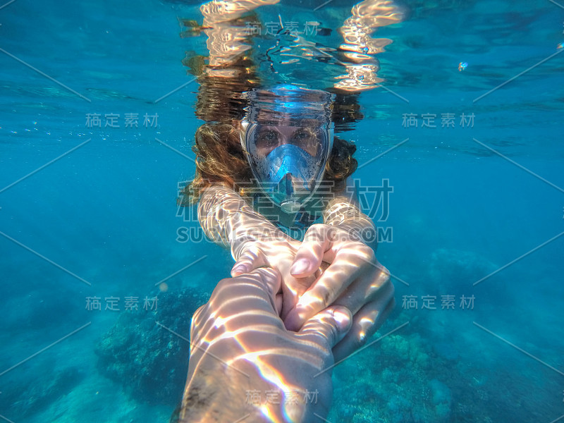 女人浮潜在蓝色的大海