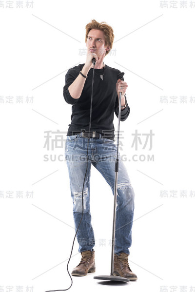 酷的时尚帅气的男摇滚摆姿势与麦克风看向别处。