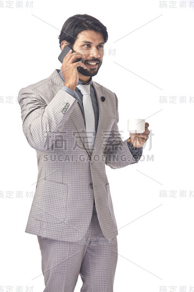 精明的年轻商人一边喝着咖啡一边打电话