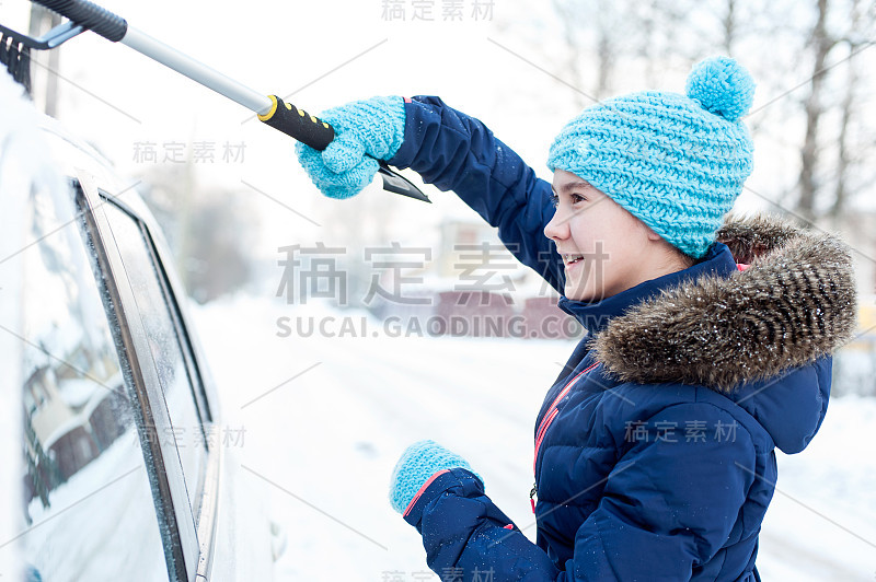 年轻漂亮的少女清理白色汽车从冬天的雪。