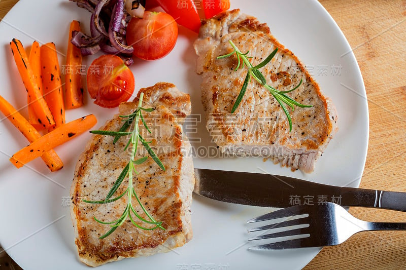 Fried pieces of pork chop with roasted vegetables 