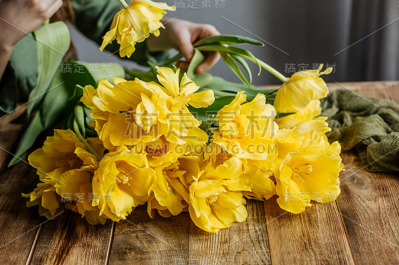 Large bouquet of yellow tulips on a wooden table