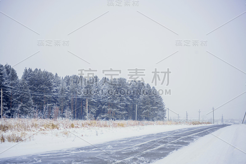 冰冻的道路。冰雪覆盖的道路和阳光照耀的蓝天。