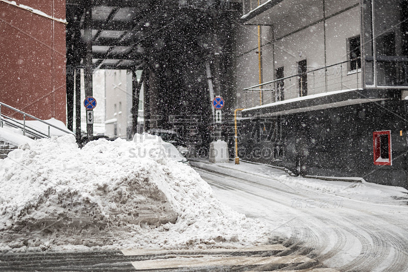 城市街道上堆积着一大堆肮脏的冰雪