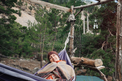 女旅行者在森林里的吊床上放松