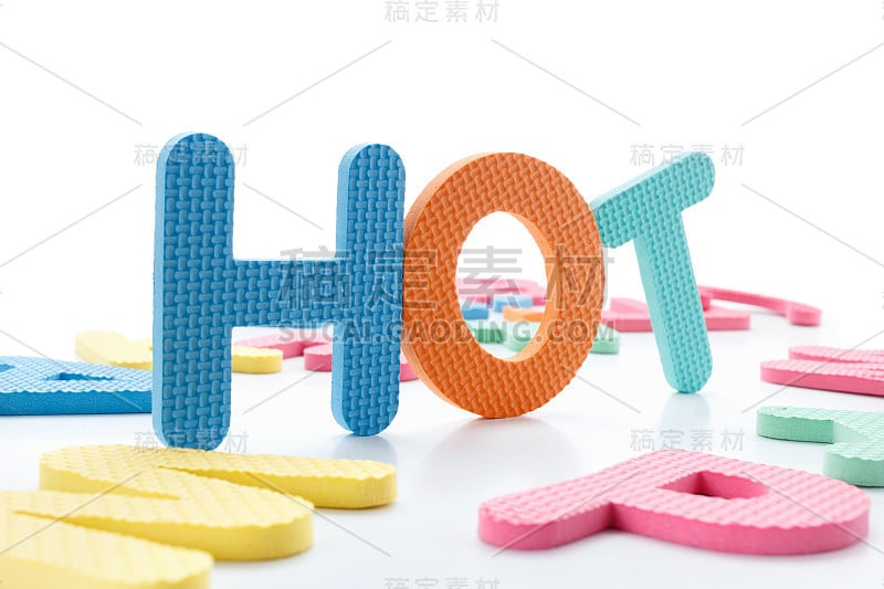 色彩鲜艳的单词“HOT”旁边一堆其他字母在白板表面组成