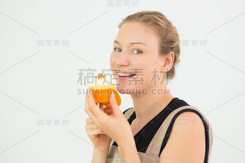 快乐的年轻白人女人吃着小蛋糕