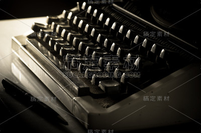 桌上放着打字机和笔。
