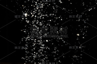 水滴在散焦的光线下在空气中滴落