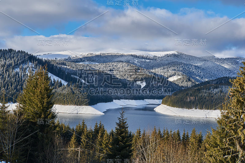 冬季景观从山上有湖，冷杉林，雪和蓝天与云