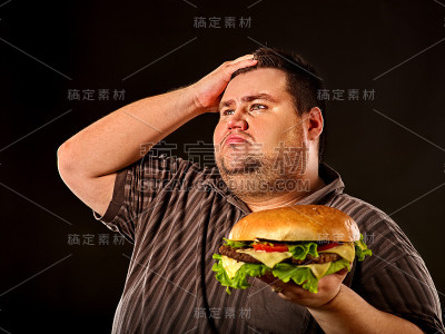 胖子吃着快餐汉堡。超重人士的早餐。