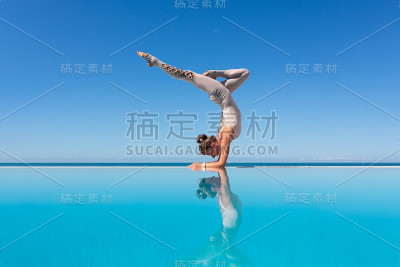 在泳池边做瑜伽的女人。