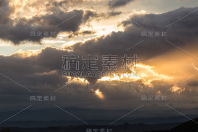 夕阳下的山谷，阳光透过一些云出来