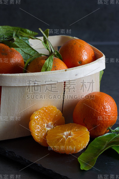 新鲜多汁的小柑橘，叶子和一个木桶