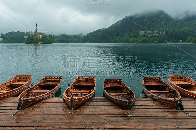 在雾蒙蒙的雨天，斯洛文尼亚，湖泊，岛屿，城堡，小船和山的背景流血