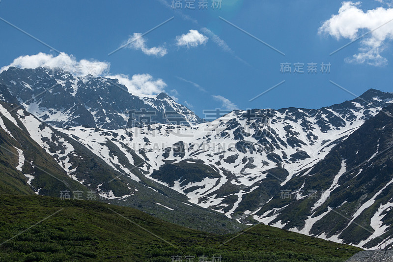 美丽的绿色山谷，覆盖着雪山的山峰