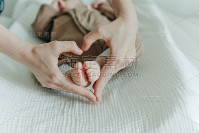 腿刚出生的婴儿和妈妈的手臂心脏