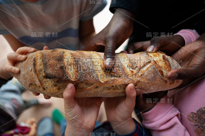 黑人和白人的孩子拿着一条面包